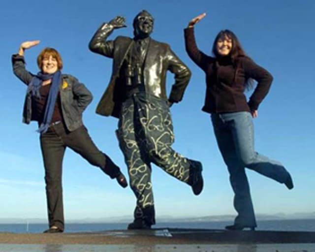 Jean-clad comedian Eric Morecambe with fans in Morecambe Bay.